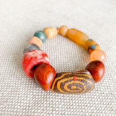 Pink, peach, yellow and greens all the bright colors of a coastal city. Features rosewood, peach jade, red coral, honey jade and jasper. African prayer beads from a weeding ceremony necklace. These prayer beads symbolize blessings, good health, happiness and long life. Comes in linen travel pouch. One of a kind. Made in USA. Artisan Wooden Beads Bracelets For Meditation, Spiritual Wooden Beads Jewelry For Blessing, Spiritual Jewelry With Wooden Beads For Blessing, Gift Jewelry With Wooden Beads And Red Coral, Earthy Wooden Beads As A Gift, Spiritual Wooden Beaded Healing Bracelets, Spiritual Agate Jewelry With Wooden Beads, Multicolor Jade Spiritual Bracelets, Spiritual Multicolor Jade Bracelets