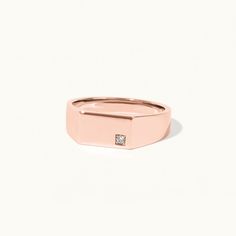 a rose gold ring with a diamond in the center and a small square stone on top