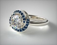 a diamond ring with blue and white diamonds on the side, set in 18k white gold