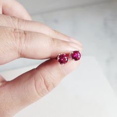 This beautiful pair of handmade stud earrings feature 2 Ruby gemstones. The stud earrings are handmade using nickel-free Argentine Silver. These studs are simple and dainty, perfect for everyday wear. Makes a great gift to add to any gemstone lover's collection. Perfect to gift for Christmas, Valentine's Day, Mother's Day, and more! Gemstone: Ruby, Simulated from Germany Gemstone Size: 6.0 mm Metal: 950 Argentine Silver (Nickel Free) Setting: 4 Prong Earring Back: Pushback **Note** We also sell Ruby Gemstone Earrings Round Cut, Nickel Free Ruby Earrings As A Gift, Nickel-free Ruby Earrings As A Gift, Nickel-free Ruby Earrings For Gift, Dainty Prong-set Earrings As Gift, Dainty Prong Set Earrings As Gift, Fine Jewelry Round Cut Earrings For Gift, Jewelry With Matching Round Stone Earrings For Gifts, Round Birthstone Earrings For Her