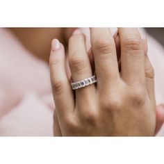 a woman's hand with a wedding ring on her left hand, in front of a pink blanket