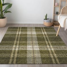 a green plaid rug in the corner of a room with a chair and potted plant