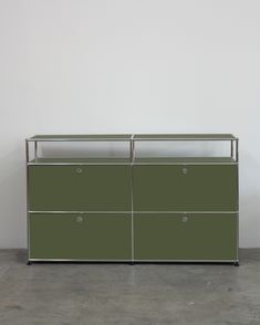 a green cabinet with three drawers and two doors on each side, against a white wall