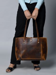 Step out in style with our handcrafted Buffalo Terry Tote. Made from luxurious Buffalo leather, this plain tote boasts a modern look and finish, perfect for your daily needs. Elevate any outfit with this sophisticated and exclusive accessory. Coffee Brown color Handcrafted & made of buffalo leather Top Handle and inside pocket Lightweight & durable leather Size in Inch 15W x 11H x 4 D Inch Size in Cm 38.1W x 27.94H x 10.16D Cm Cool Messenger Bags, Plain Tote, Coffee Brown Color, Best Travel Bags, Waxed Canvas Bag, Handmade Leather Bag, Handmade Leather Bags, Duffel Bag Backpack, Best Wallet