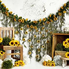 sunflowers and greenery are arranged on the wall