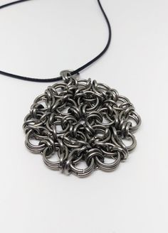 a necklace made out of metal rings on a black cord