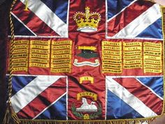 an old british flag with some gold trimmings on it's edges and the royal crest