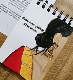 a drawing of a woman's profile on top of a notepad next to an open book