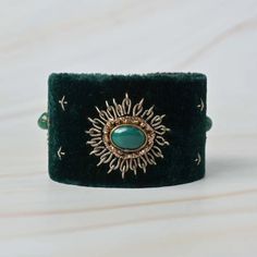 Elevate your wrist with our Handmade green Zardozi Embroidered Velvet Hand Bracelet, a mesmerizing fusion of traditional craftsmanship and contemporary elegance. Expertly embroidered with intricate Zardozi work in a lush green hue, this bracelet exudes opulence and charm.  Size(cm): 6*5*4 Material: Velvet Fabric & Metal Thread Stones: Green Onyx Base Color: Green Adding to its allure, the centerpiece features a captivating green onyx, known for its soothing energies and striking appearance Whether paired with ethnic wear or to complement an evening ensemble, this bracelet is a testament to artistry and luxury. - Handmade with precision by skilled artisans. - Luxurious green velvet exudes regal charm. - GREEN ONYX Sandstone centerpiece adds a touch of mystique. - Perfect for special occasio Green Adjustable Cuff Bracelet For Wedding, Adjustable Green Cuff Bracelet For Wedding, Elegant Adjustable Decorative Bracelets, Handmade Green Bangle For Festivals, Handmade Green Bangle For Festival, Adjustable Embroidered Festive Jewelry, Traditional Green Adjustable Cuff Bracelet, Traditional Adjustable Green Cuff Bracelet, Green Bangle Jewelry For Festivals