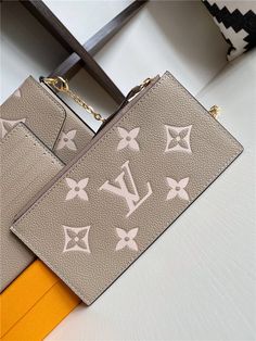 two louis vuitton wallets sitting on top of each other next to an envelope