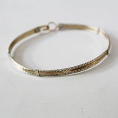 "A terrific little bracelet of six strands of wire--two plain 14kt gold filled wires on the inside, flanked by four sterling silver twist wires on the outside. Charming, comfortable, and feminine, and two-tone is really \"in\" right now! The sturdy built-in hook and eye clasp is easy to get on and off by yourself. This bracelet can also be made in all 14kt gold filled or all sterling silver. They would look AMAZING all three stacked together! Choose your size from the variations listed for a cus Silver And Gold Bracelet, Bangle Silver, Twisted Wire, Stackable Bracelets, Hook And Eye, 14kt Gold, Silver And Gold, Gold Filled, Two Tone