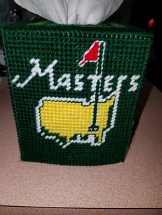 a tissue dispenser made out of green material with the word masters on it