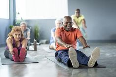 an older man and woman doing yoga on mats with their feet up in the air