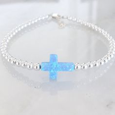 Crosses represent self, nature, faith, wisdom, hole, unity, and love! This beautiful bracelet or necklace is made with a brilliant lab-created opal cross in either white or blue. Choose between 3 finishes: sterling silver, gold filled, or rose gold filled. One inch of extra chain lets you adjust the bracelet to your preference. All items are hand-made in the USA in a smoke-free studio, and most importantly, they're made with OurWholeHeart❤︎ ------------------------------------------------------- Spiritual Cross Bracelets As Gifts, Nickel Free Cross Bracelet With Spiritual Style, Nickel-free Cross Bracelet For Spiritual Style, Spiritual Sterling Silver Bracelets, Spiritual Cross Bracelets, Sterling Silver Friendship Spiritual Bracelets, Nickel-free Cross Bracelet Gift, Silver Cross Jewelry For Friendship, Spiritual Cross Beaded Bracelets As Gift