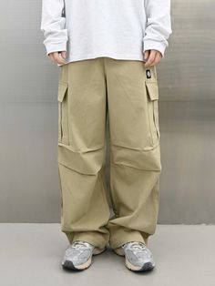 It is a comfy wide fit cargo pant for unisex. The pant is designed to fit different body shapes with the elastic band on the back of the waist and belt loops. The pleats on the waist and on the knee makes comfy fit and adds volume to the silhouette. The pant features multiple cargo pockets as a point.- Elastic waist- Drawcords on the hem- Back pocket- Twill fabric- Symbol patch Khaki Straight Cargo Jeans For Streetwear, Baggy Solid Color Hip Hop Cargo Pants, Baggy Khaki Cargo Pants With Belt Loops, Urban Full-length Cargo Pants With Belt Loops, Urban Style Full-length Cargo Pants With Belt Loops, Urban Style Full Length Cargo Pants With Belt Loops, Utility Baggy Wide Leg Pants With Belt Loops, Hip Hop Wide-leg Pants With Pockets, Hip Hop Style Wide-leg Pants With Pockets