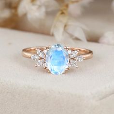 an oval cut blue topaz ring with diamonds on the sides and side stones in the middle