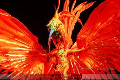 a woman dressed in red and orange with wings