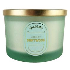 a candle that is green and white with gold trimming on the lid, sitting in front of a white background