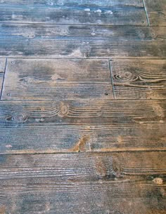 an old wooden floor with peeling paint and chipped wood grains on the top