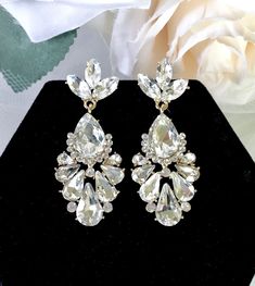 A delightfully unique pair of bridal earrings with an incredible sparkle! Lightweight, the earrings are adorned with flawlessly faceted rhinestone crystals that capture the light in a dazzling array of sparkles, and are rhodium/gold plated for a bright finish which enhances the intricate detailing and conveys a modern take on old elegance. Length: 2" (approx. 5cm). Available in Silver and Yellow Gold finishes. To make your choice select your preferred finish from the dropdown menu. Hypoallergeni Bridal Earrings Silver, Silver Bridal Earrings, Floral Heels, Bridal Belt, Rhinestone Bridal, Bridal Bracelet, Bridal Tiara, Simple Bags, Rhinestone Jewelry