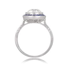 "Notable for it's size, this ring features a 4.49 carat natural Sapphire. Along the shoulders are two additional step-cut sapphires, followed by graduating baguette-cut diamonds. This ring is vintage, circa 1960. ✦ SAPPHIRE SPECIFICATIONS: Sapphire Cut: Cushion Cut Sapphire Weight 4.49 Carats ✦ ENGAGEMENT RING SPECIFICATIONS: Ring Material: Platinum Stones: Diamond, Sapphire ✦ WHAT COMES IN YOUR SHIPMENT: - Your Engagement Ring - Quality Ring Box - Jewelry Cleaner - UGL Certificate ✦ WHY SHOP WI Timeless Sapphire Ring With Baguette Cut Center Stone, Timeless Sapphire Ring With Baguette Cut, Timeless Emerald Cut Sapphire Ring With Center Stone, Timeless Asscher Cut Sapphire Ring, Diamond White Emerald Cut Sapphire Ring In Platinum, Emerald-cut Diamond White Sapphire Ring In Platinum, Emerald Cut Lab-created Sapphire Ring With Center Stone, Emerald Cut Lab-created Sapphire Ring, Timeless Emerald-cut Sapphire Ring With Bezel Setting