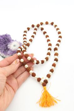 These beautiful beads are made from Rudraksha seeds paired with pearls. Hailing from India, Rudraksha seeds are traditionally used as prayer beads in Hinduism. They are the seeds of the Rudraksha tree, and legend has it that when Lord Shiva awoke from a long meditation, he shed a tear; from this tear grew the Rudraksha tree.Pearls are known as "moti" in Hindi, and they are symbolic of the moon. They encourage positive thinking and balance, and are believed to attract good luck and wealth. Bead S Spiritual Beaded Necklace With Spacer Beads For Festivals, Spiritual Beaded Necklaces With Spacer Beads For Festivals, Traditional White Jewelry For Healing, White Pearl Jewelry For Puja, Traditional White Healing Jewelry, White Polished Beads Jewelry For Puja, White Gemstone Beads For Festivals, Temple Jewelry Pearl Necklace For Puja, Spiritual White Jewelry For Diwali