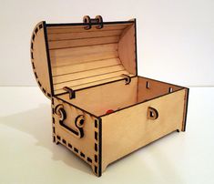 an open wooden box sitting on top of a white table next to a red object