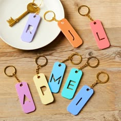 four different colored keychains with the word me on them sitting next to each other