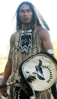 a native american man with an eagle on his chest and headdress holding a drum