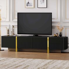 a flat screen tv sitting on top of a wooden entertainment center in a living room