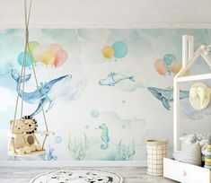 a child's room decorated in pastel colors with balloons and sea animals on the wall