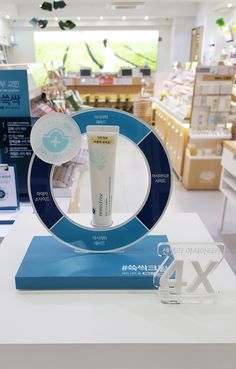 a white table topped with a tube of toothpaste next to a blue and white sign