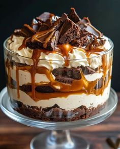 a cake with chocolate and caramel drizzled on top sitting on a glass plate