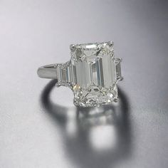 an emerald cut diamond ring on a table