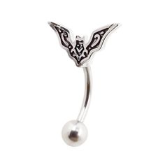 a silver belly ring with a black and white design on the front, featuring a bat