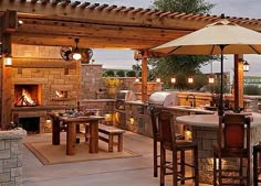 an outdoor kitchen and dining area is lit up at night