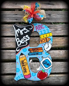 a wooden letter decorated with school supplies