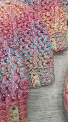 three crocheted hats with tags on them