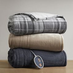 three blankets stacked on top of each other with an electric heater in the middle