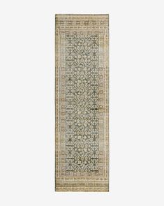 a beige and green rug with an intricate design on the bottom, in front of a white background