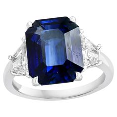 a blue sapphire and diamond ring with three diamonds on the band, set in white gold