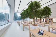 a room filled with tables and benches next to a large window covered in glass walls