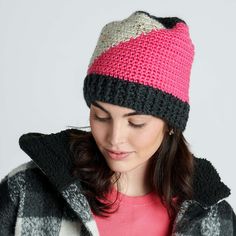 a woman wearing a pink and black knitted hat