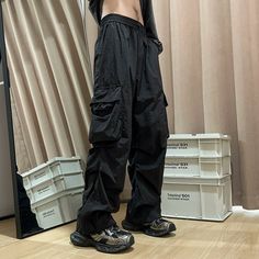 a person standing in front of a mirror wearing black pants and shoes with their hands on their hips