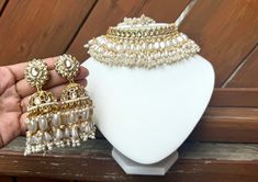 Gold and white choker set White Festival Choker, White Chandbali Bridal Sets For Ceremonies, White Bollywood Hand Set Jhumkas, White Bollywood Style Hand Set Jhumkas, White Jewelry Sets As Eid Gifts, White Jewelry Sets For Eid Gift, White Jewelry Sets For Wedding On Eid, White Jewelry For Diwali Party, Festival Handcrafted White Jhumkas