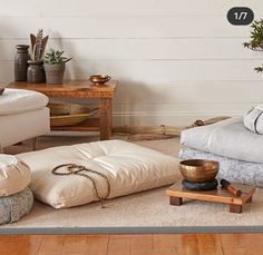 a living room filled with lots of furniture and decor on top of a wooden floor