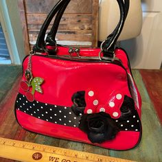 Disney Red Vinyl Purse With Black Vinyl Handles, Black With White Polka Dots, Satin Black Flowers, Two Metal Charms, One Cherries And One Heart. Snap Top Closure. Zipper Pocket Inside. 12”W X 9”H X 4.5”D. New With Tags. Excellent Condition. Cute Red Satchel Bag, Red Disney Bag With Zipper Closure, Cute Red Bag With Removable Pouch, Cute Red Bags With Removable Pouch, Cute Red Satchel For Daily Use, Disney School Bag In Red, Red Disney School Bags, Disney Red School Bag, Cute Red Satchel For Everyday Use