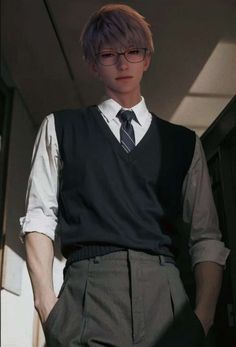 a young man wearing glasses and a vest