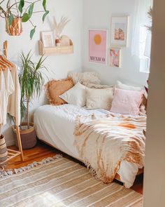 a white bed sitting next to a wooden floor in a room with lots of pictures on the wall