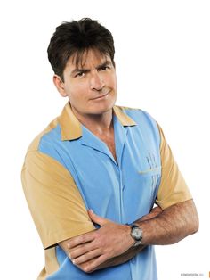 a man with his arms crossed wearing a blue shirt